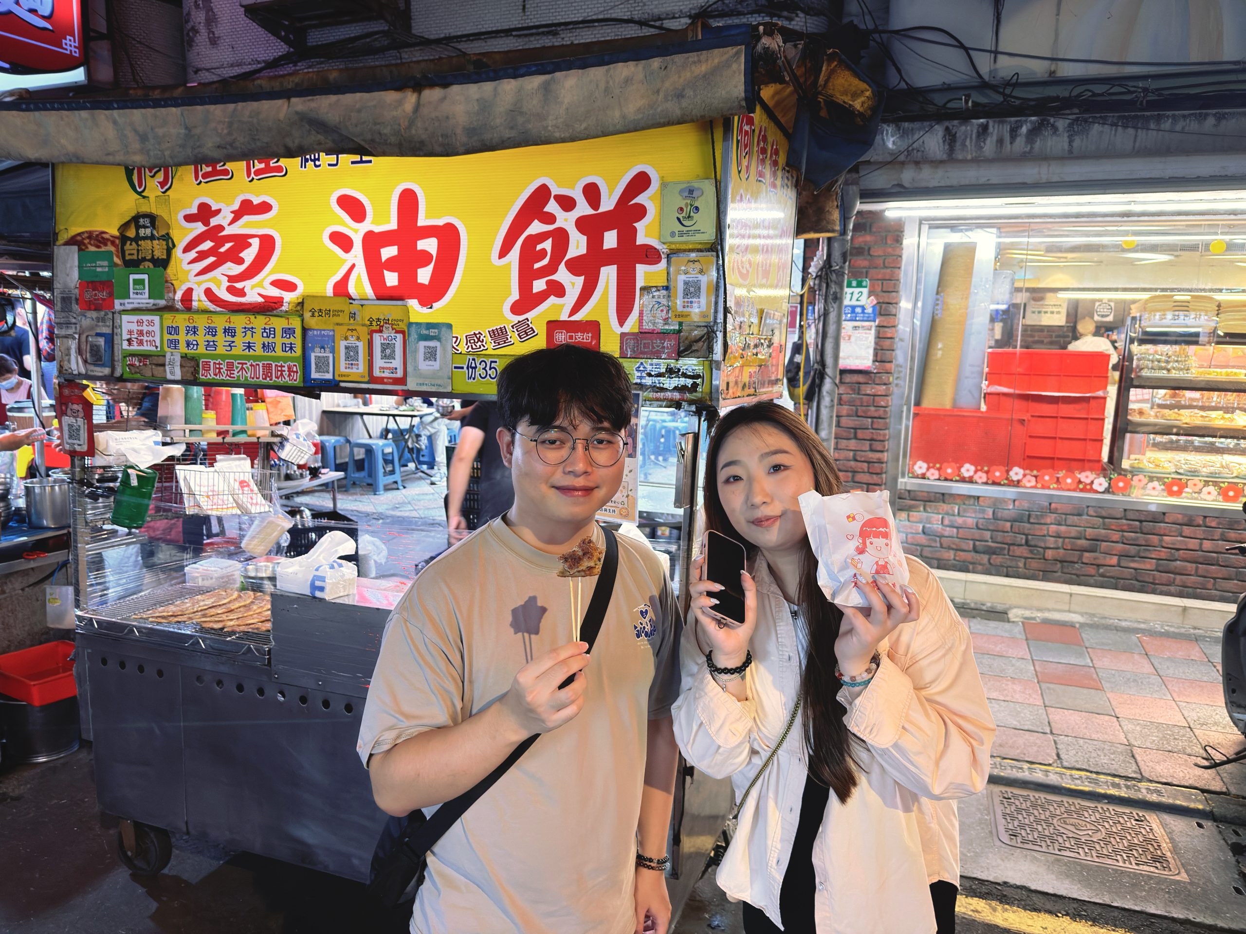 大學生創作者走訪大龍夜市,分享蔥油餅及地瓜球等經典臺灣味小吃。圖/臺北市市場處提供