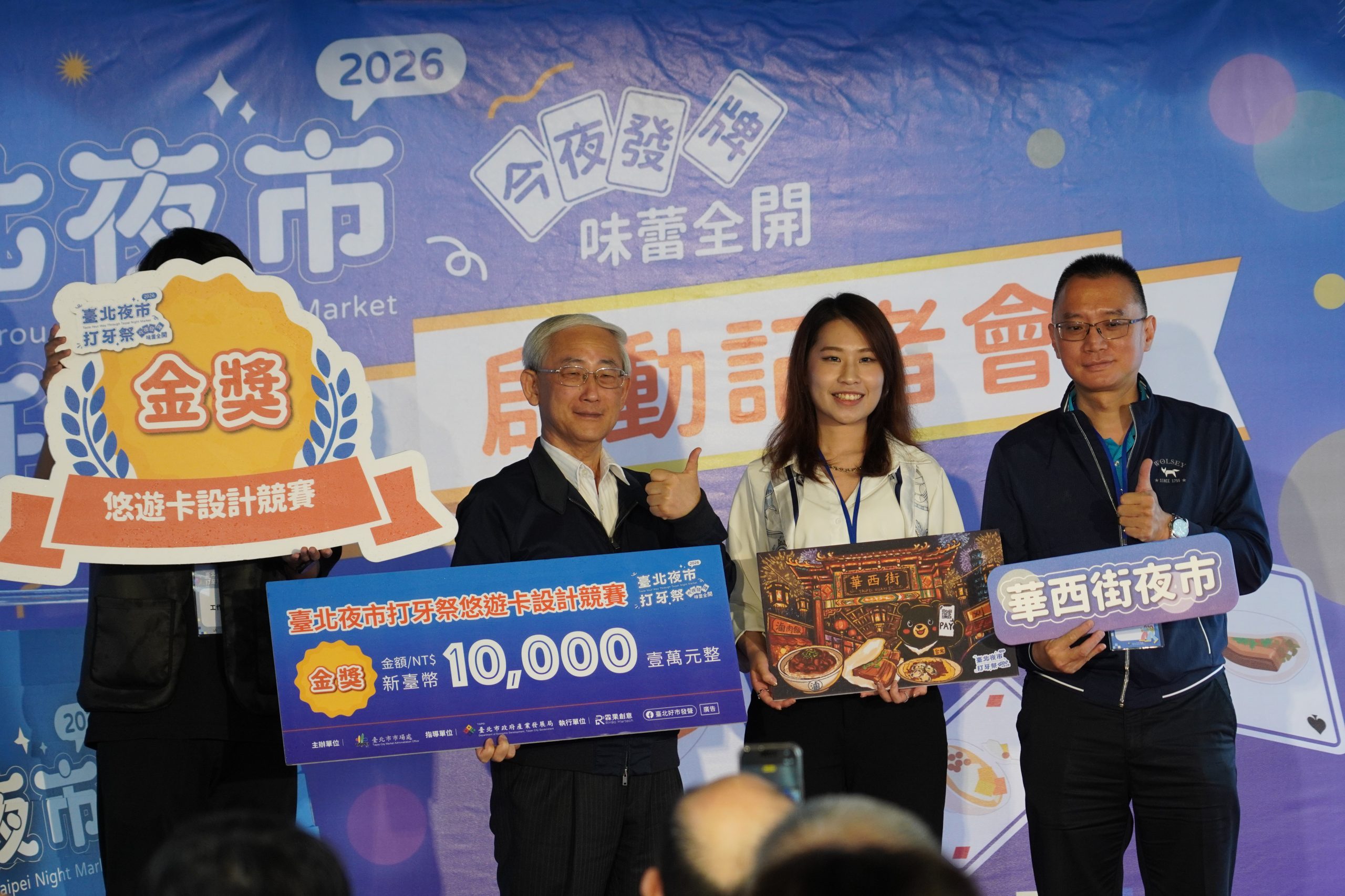 悠遊卡設計競賽金獎得主(右二)與臺北市市場處黃宏光處長(左二)及華西街夜市鄭育青理事長(左一)共同合影。